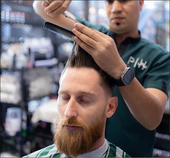 Barber performing a scissor cut at Project Hairway